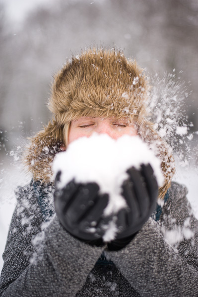 Meisje blaast sneeuw weg