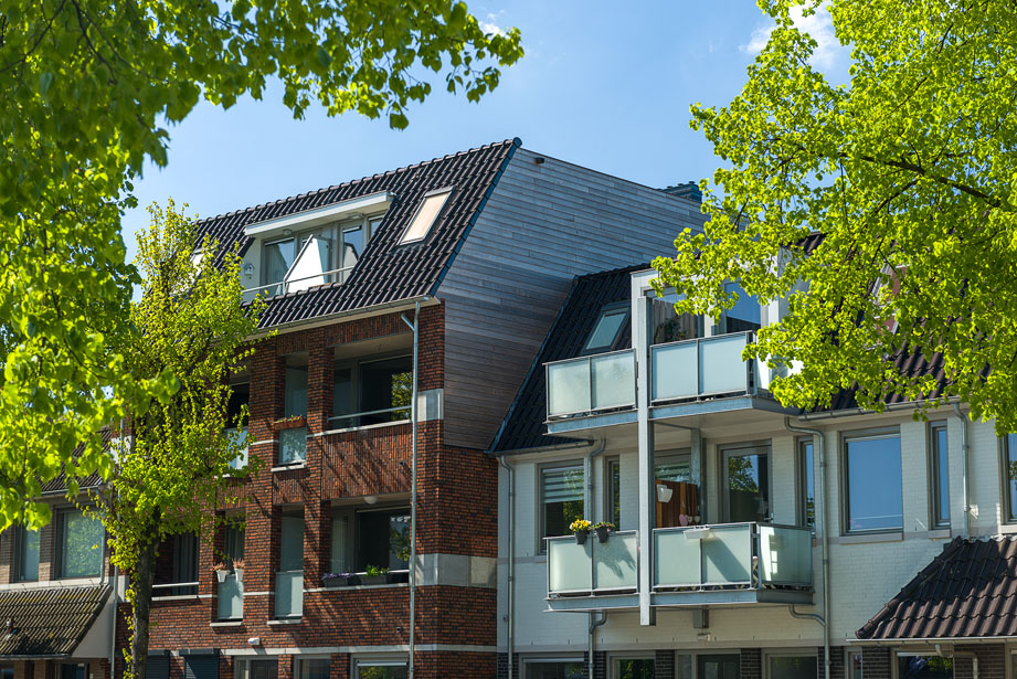 Nieuwbouwproject in Uden met groene bomen en blauwe lucht